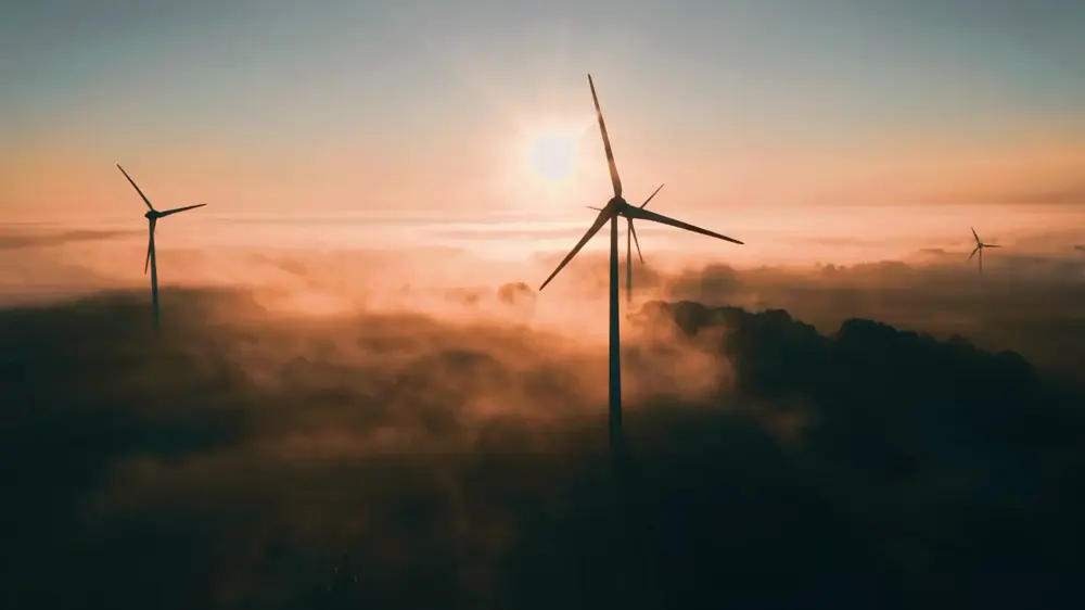 Éoliennes au-dessus des nuages avec un temps ensoleillé, en fin d'après-midi